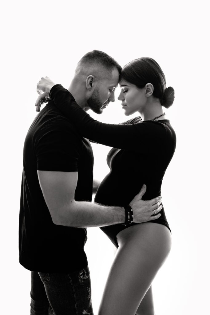 Rodzice i starsze dziecko przytulające brzuszek - rodzinna sesja