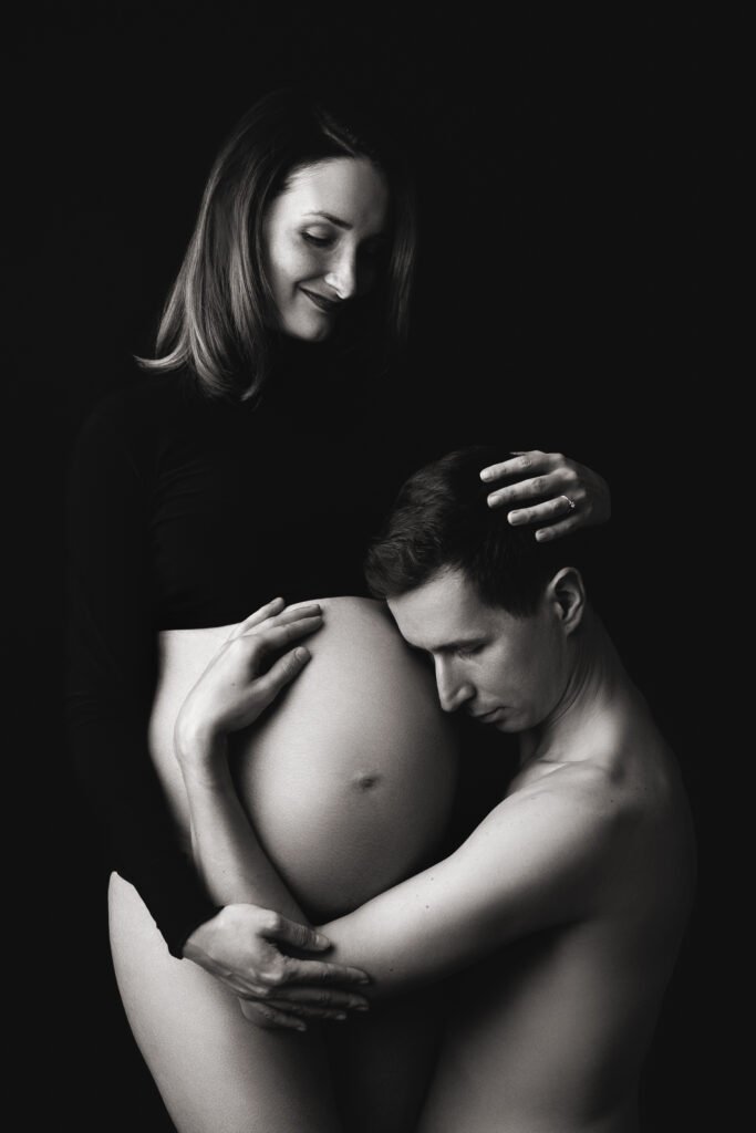 Czarno-białe zdjęcie brzucha z dramaturgicznym cieniem